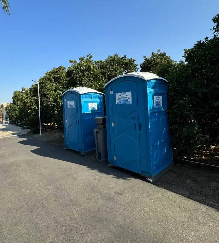 two porta potties and portable handwash station in central valley