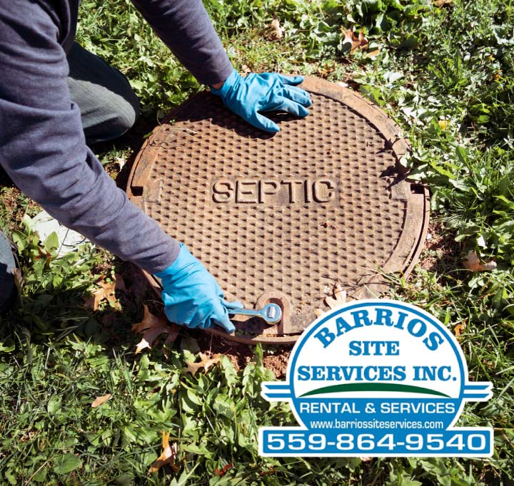 A trained technician using a wrench to securely open a heavy-duty septic tank cover for a scheduled maintenance and diagnostic service.