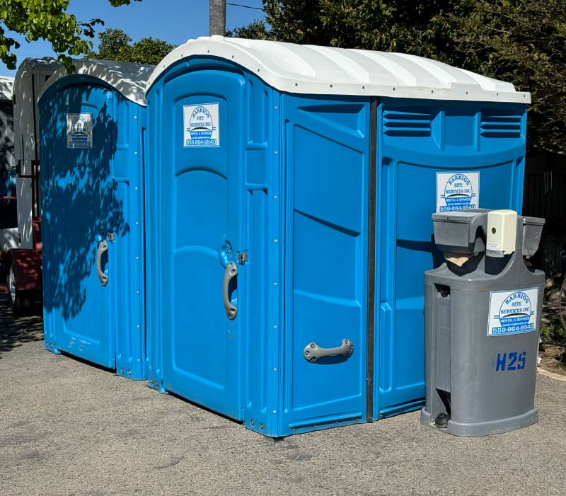 Wheelchair-accessible ADA portable toilet rental from Barrios Site Services, featuring a spacious interior design and integrated handrail for compliance at public events and job sites.