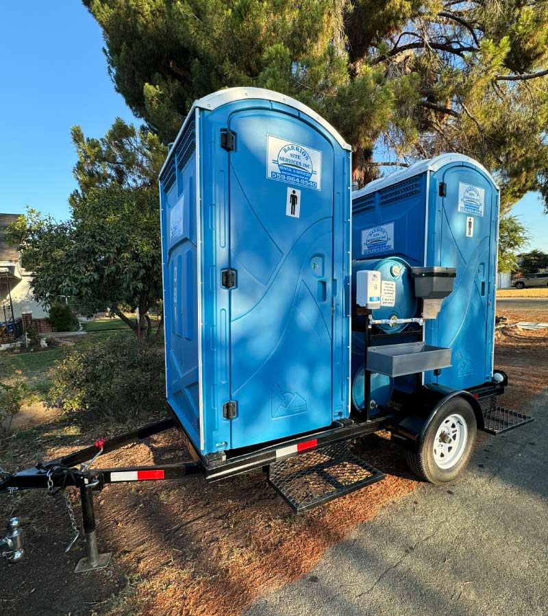 Barrios Site Services double towable portable toilet unit mounted on a trailer with a 2-inch ball hitch, including a custom external handwash station for mobile work crews in Madera County.
