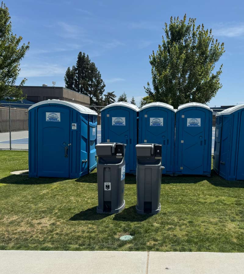 A fleet of clean Barrios Site Services portable toilets and dual-sided standalone handwash stations ready for delivery to large-scale events and job sites in Tulare and Kings County.