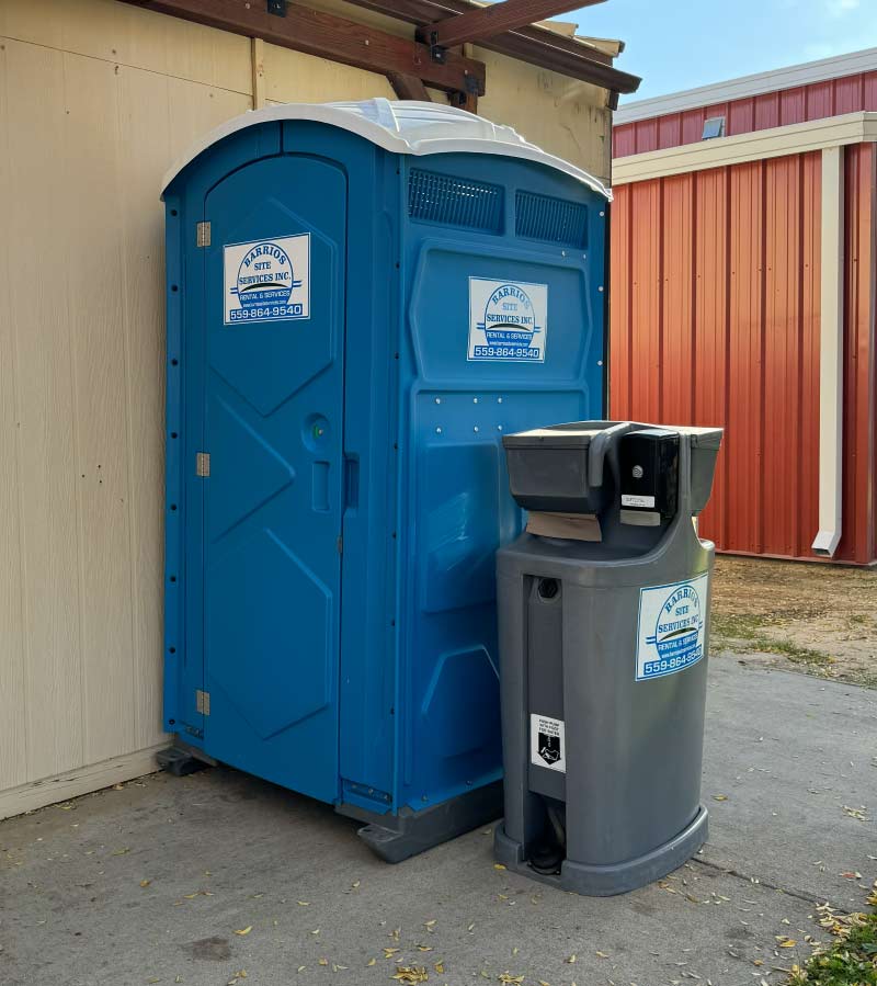 Barrios Site Services deluxe portable restroom unit with integrated foot-pump operated handwash station, soap dispenser, and paper towels for high-hygiene emergency sanitation needs